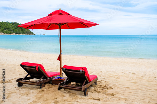 Red beach umbrella and beach chairs on a beautiful Island