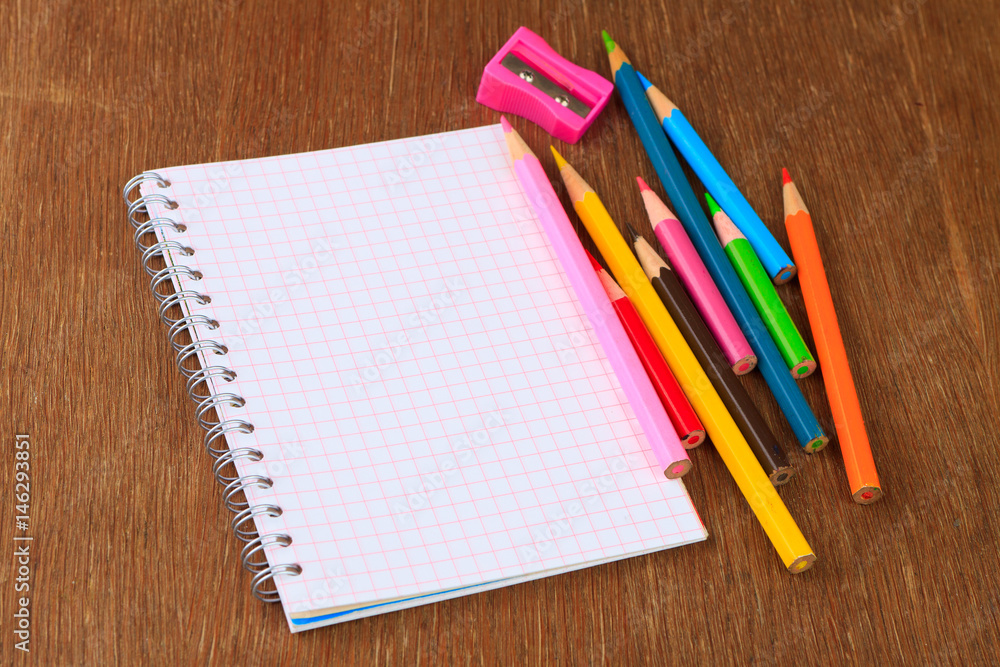 Colored pencils, pencil sharpener and notebook Colored pencils, pencil sharpener and notebook