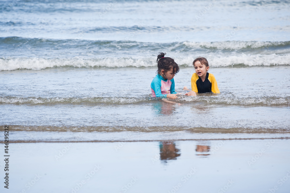 Obraz premium Little girls playing on the beach, family beach vacation