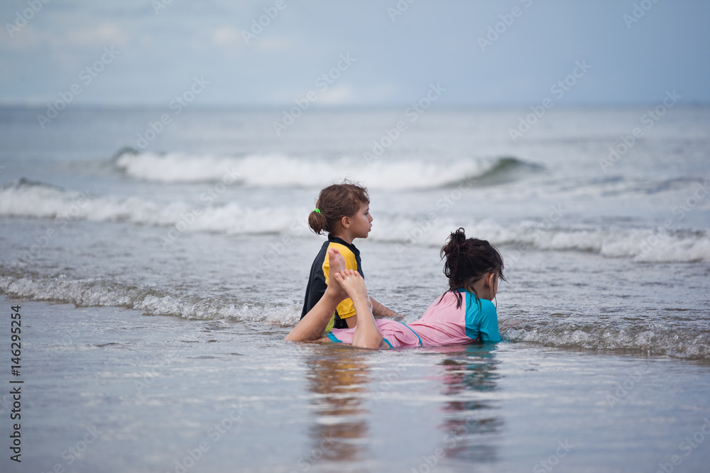 Little girls playing on the beach, family beach vacation Little girls playing on the beach, family beach vacation