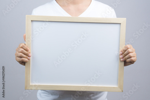 Woman hand holding blank wooden frame