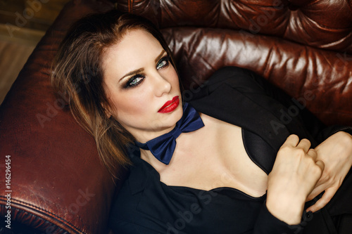 Femme fatale on leather couch