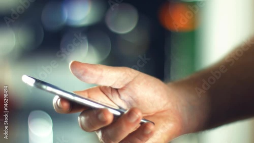 Using a Smartphone, sliding the screen and taping, close up shot with soft bokeh