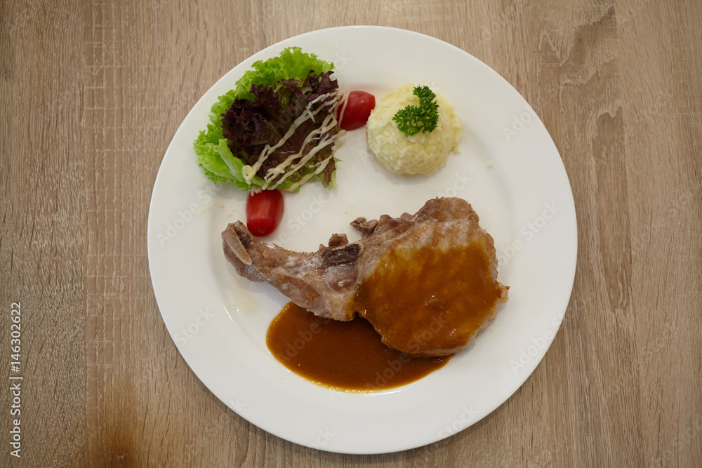 Pork chops steaak grilled with black pepper sauce and salad on white plate. Pork chops steaak grilled with black pepper sauce and salad on white plate.