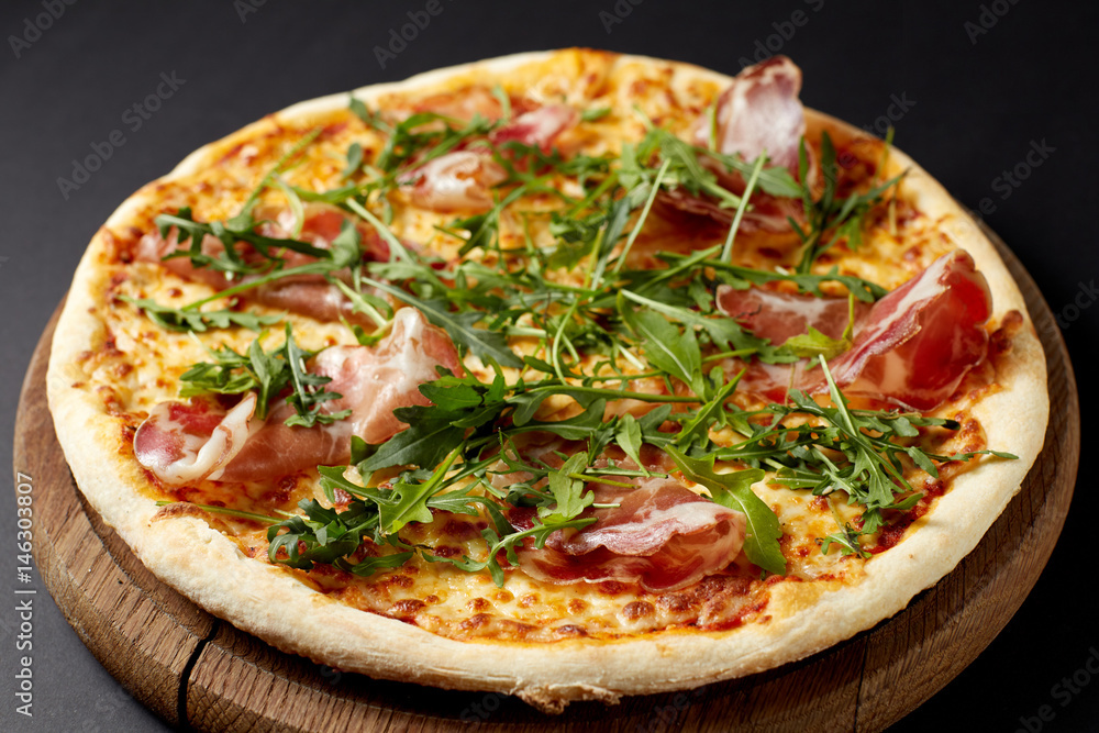 Hot pizza Prosciutto on a rustic wooden table. Hot pizza Prosciutto on a rustic wooden table.