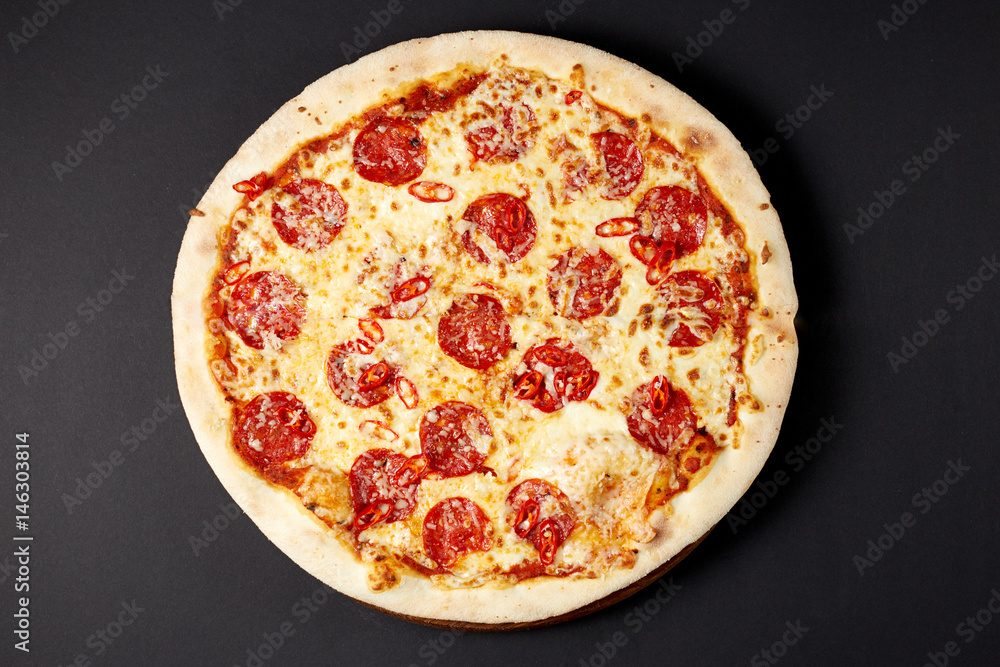 Hot pizza Diablo on a rustic wooden table.