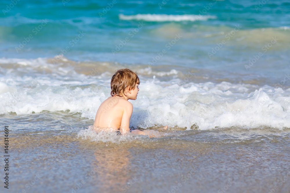 little blond kid boy having fun on ocean beach in Florida little blond kid boy having fun on ocean beach in Florida