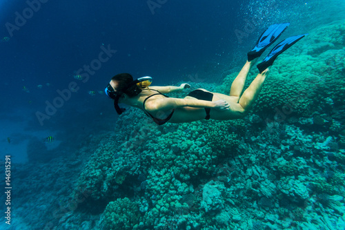 Young girl at snorkeling in the tropical water. Traveling, active lifestyle concept.