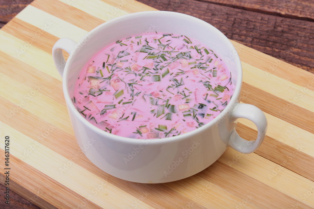 Popular spring cold soup okroshka with yoghurt. Okroshka in a bowl on wooden table. Selective focus Popular spring cold soup okroshka with yoghurt. Okroshka in a bowl on wooden table. Selective focus