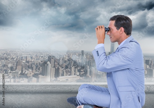 Business man with bionoculars against grey skyline and clouds photo