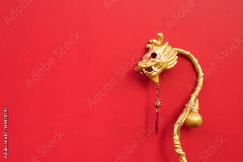 Golden Chinese style dragon wand on red background