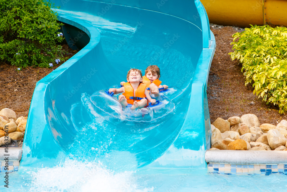 excited children in water park riding on slide with float Stock Photo ...