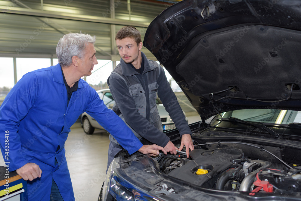 student with instructor repairing a car during apprenticeship student with instructor repairing a car during apprenticeship