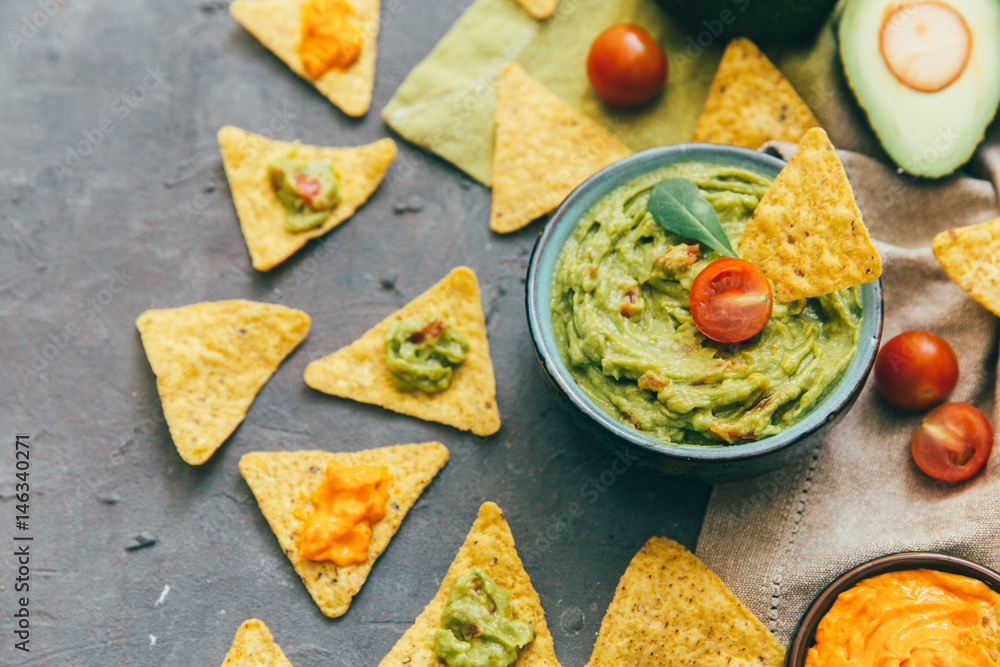 Nachos with guacamole and fresh ingrediens on a gray background. Nachos with guacamole and fresh ingrediens on a gray background.