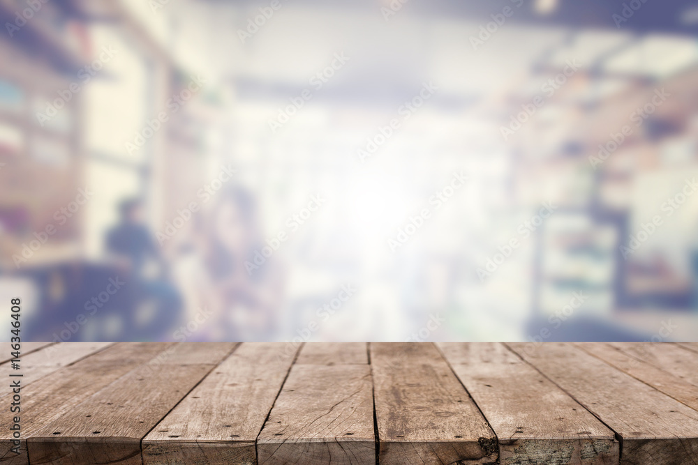 Wood table top with abstract blurred coffee shop background Wood table top with abstract blurred coffee shop background