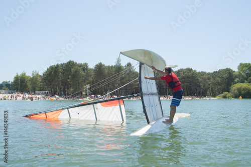 salior trying to right his catamaran after capsize photo