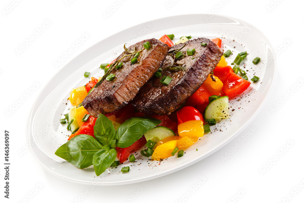 Grilled beefsteak with vegetables on white background Grilled beefsteak with vegetables on white background