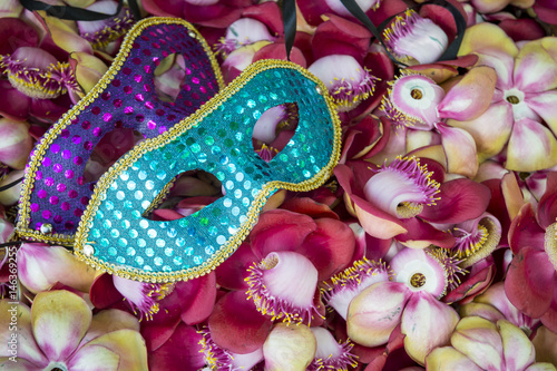 Colorful carnival masks rest on bright tropical flower background in Rio de Janeiro, Brazil
