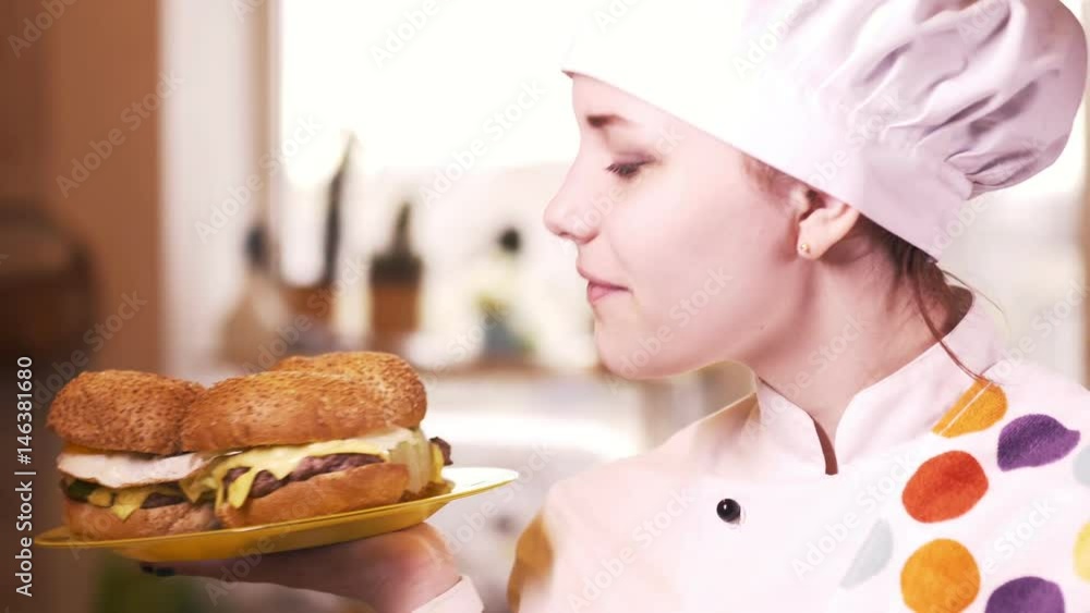 Beautiful blonde young cook girl with hamburger. 4K Beautiful blonde young cook girl with hamburger. 4K