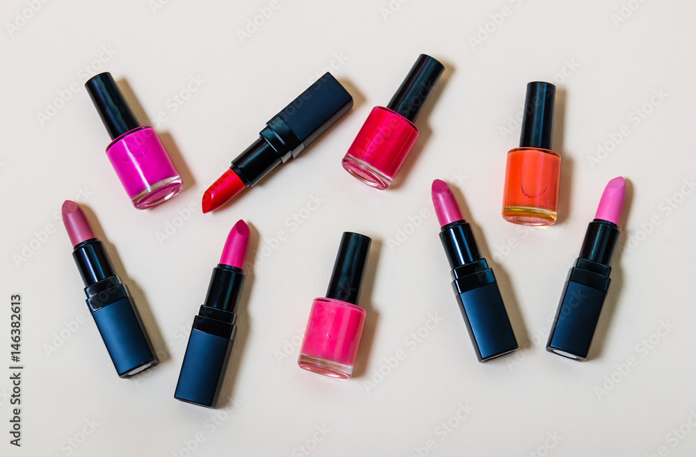 Obraz premium Set of lipsticks and nail polishes on beige background