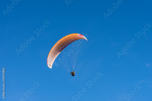 Parachutist over sky background