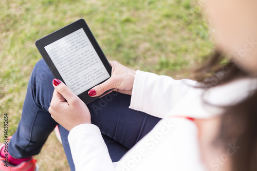 Attractive young woman with e-book/tablet in the park photo
