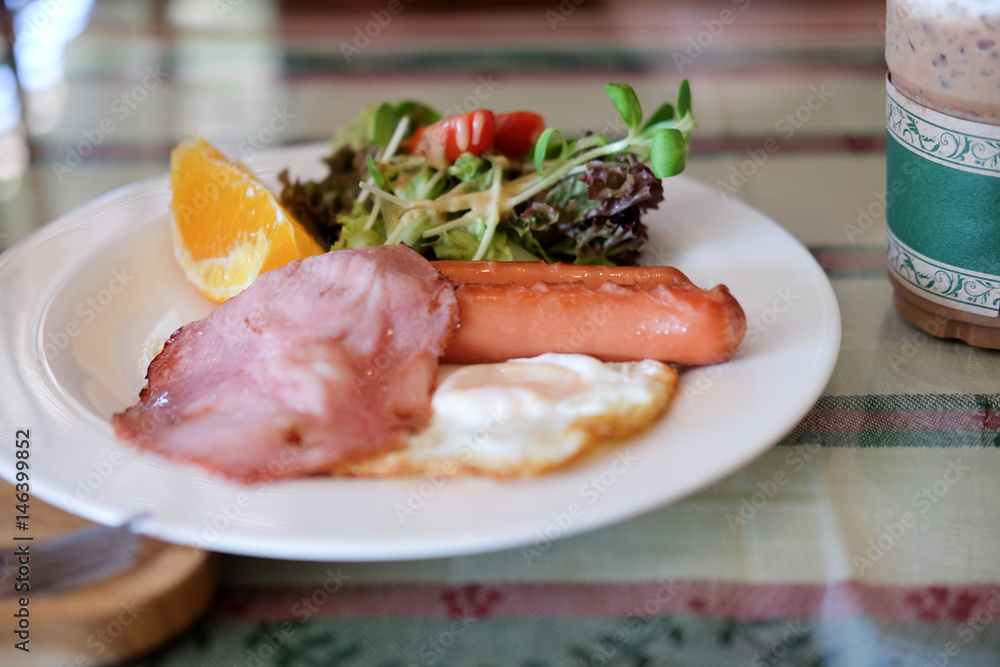 Breakfast with hotdog fried egg and salad Breakfast with hotdog fried egg and salad