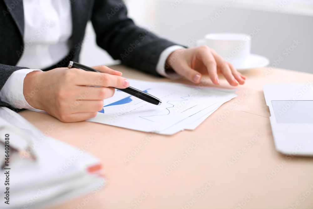 Business woman sitting at the table and examines the financial results Business woman sitting at the table and examines the financial results