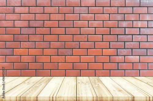 Empty wooden table top with red brick wall texture background.