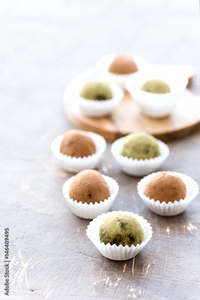 Homemade healthy vegan chocolate truffles rolled cocoa and matcha powder Vertical photo
