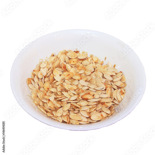 Plate with dried white sunflower seeds isolated on white background.