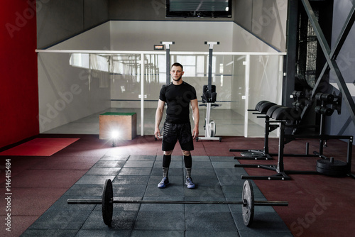 Bearded man preparing to training with a barbell in gym