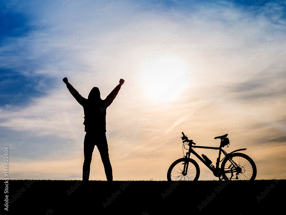 Cyclist and bicycle silhouettes on the dark background of sunsets