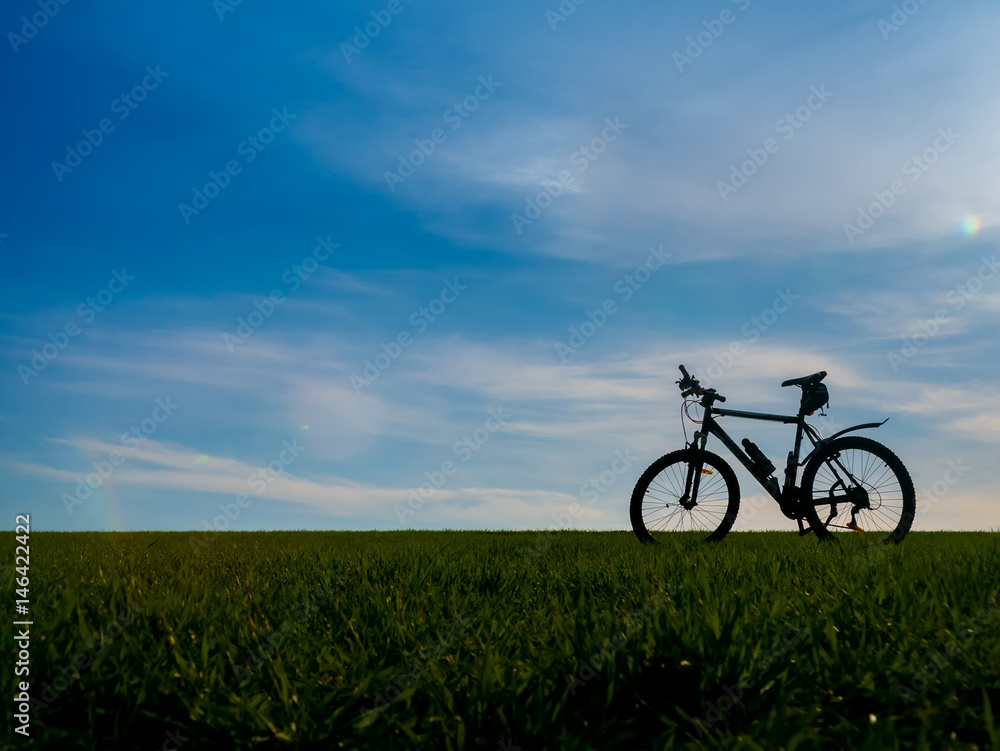 Bicycle silhouettes on the dark background of sunsets Bicycle silhouettes on the dark background of sunsets