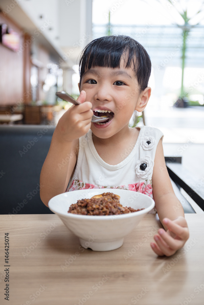 Asian little Chinese girl eating braised pork rice Asian little Chinese girl eating braised pork rice