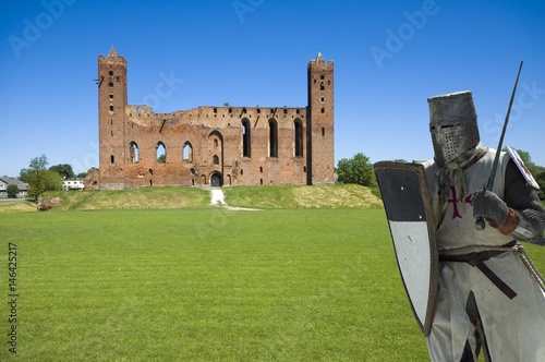 Medieval knight and ruins of conventual Gothic style castle of the Teutonic Knights' Commandry in Radzyn Chelminski, Poland photo