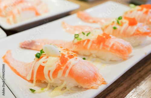 Grilled toro salmon sushi (sake nigiri) with shrimp eggs (tobiko) and mayonnaise serve on white plate , Japanese food.