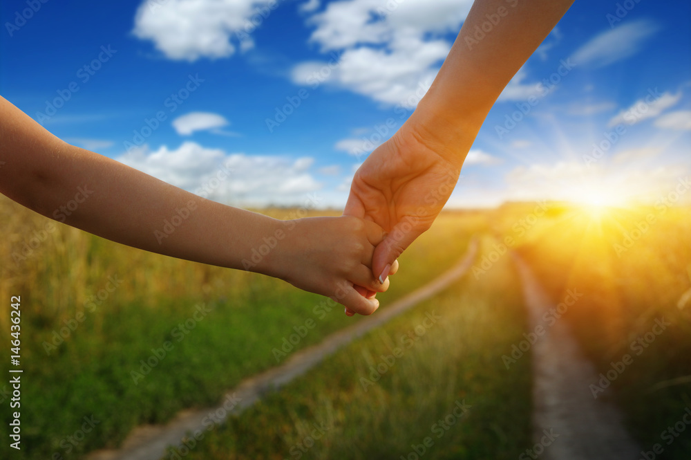 Hands of holding each other in field Hands of holding each other in field