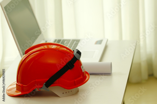 Stock Photo - Orange Safety helmet and norebook on white table photo