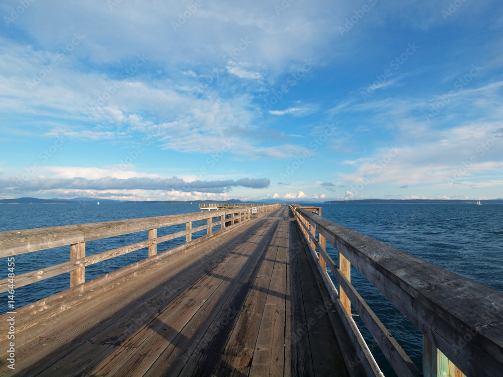 Wooden fishing pier extending from the shore into the ocean. Sidney BC, Vancouver Island