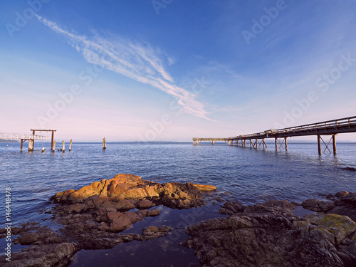 Wooden fishing pier extending from the shore into the ocean. Sidney BC, Vancouver Island © pr2is