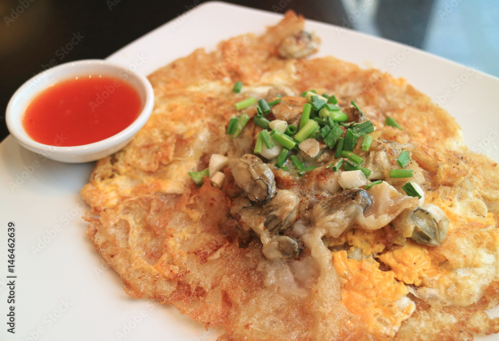 Fried oysters crispy omelette with sweet and spicy dipping sauce severed on white plate Fried oysters crispy omelette with sweet and spicy dipping sauce severed on white plate