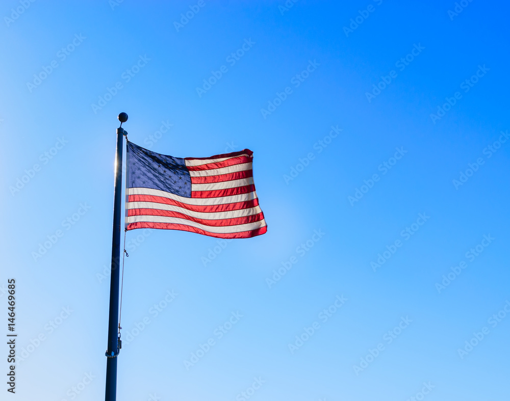 USA flag in wind with blue sky background USA flag in wind with blue sky background