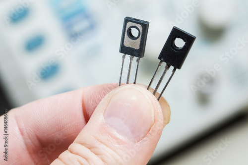 Man holding two transistor semiconductor photo