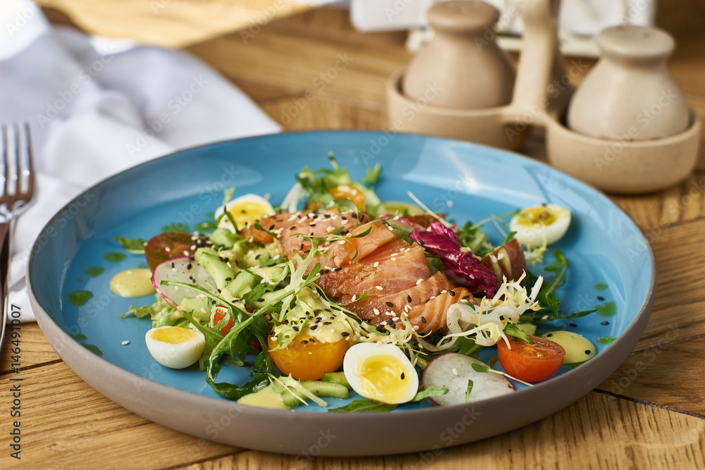 Vegetable salad with cucumber, lettuce, cherry tomatoes, salmon and eggs