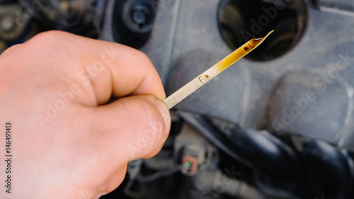 checking the oil level in a car engine 