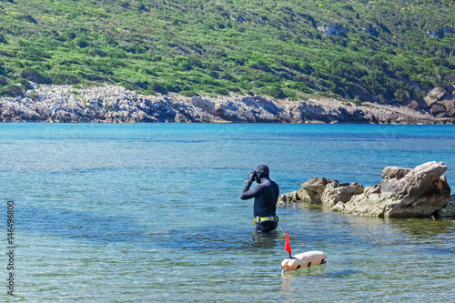 Underwater hunter getting ready to snorkeling on Aegean sea in Greece.