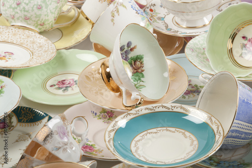 High resolution close-up of a beautiful antique tea cups and saucers collection, isolated on a white background.