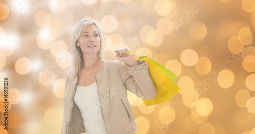 Woman holding shopping bags while looking away