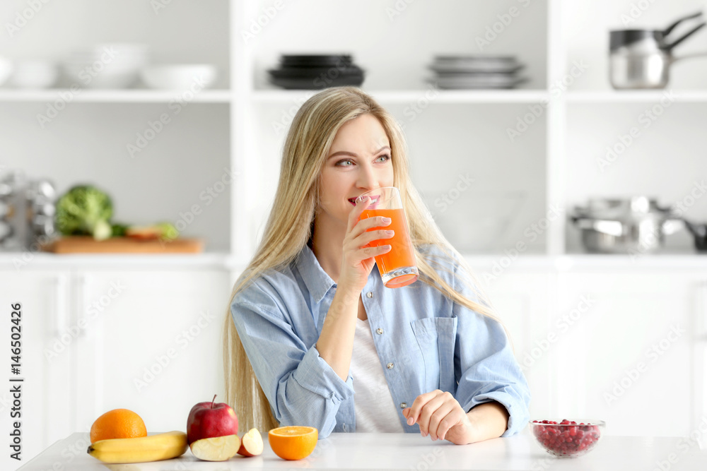 Beautiful young woman drinking fresh juice in kitchen Beautiful young woman drinking fresh juice in kitchen